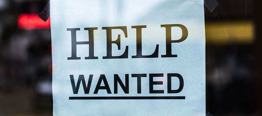 A "Help Wanted" sign in a window.