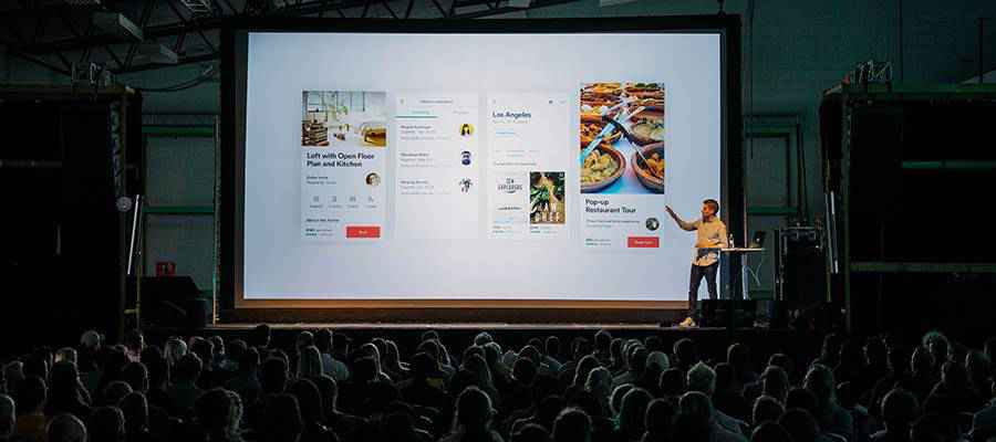 A conference presentation on a stage.